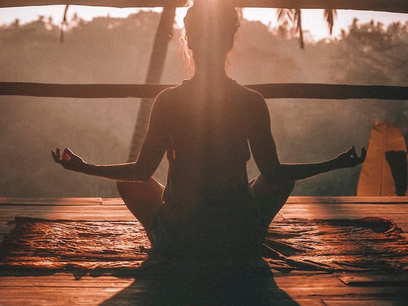 Person meditating outdoors at sunrise — mental-emotional foundations of naturopathic care